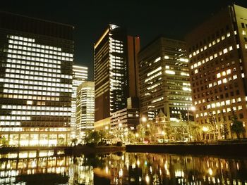 Illuminated cityscape against sky at night