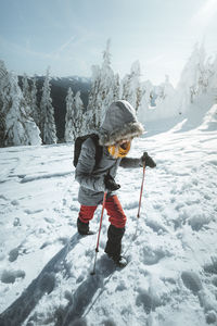 Full length of child on snowcapped mountain against sky