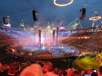 Crowd at music concert against sky at night