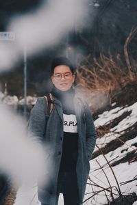 Portrait of young woman standing in snow