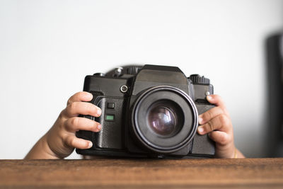 Cropped hands of baby holding camera