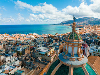 High angle view of townscape by sea against sky