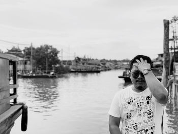 Portrait of man standing by canal