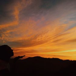 Silhouette of mountain against dramatic sky