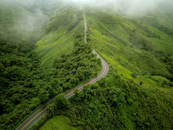 Countryside road passing through the lush green tropical rain forest mountain landscape