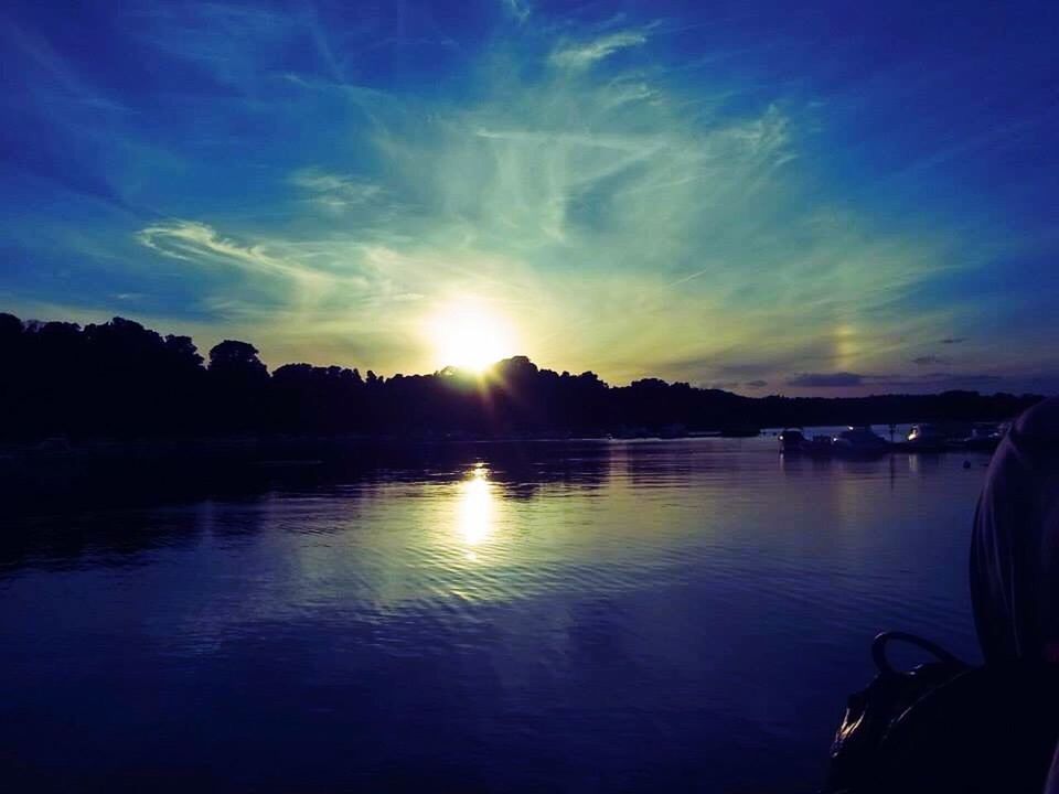 sunset, water, sun, reflection, tranquil scene, scenics, silhouette, tranquility, beauty in nature, lake, sky, sunlight, nature, idyllic, sunbeam, waterfront, cloud - sky, orange color, river, lens flare