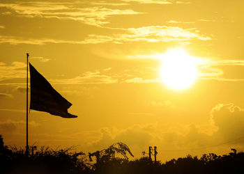 Silhouette flag against sky during sunset