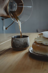 Traditional semla bun on plate and pouring coffee