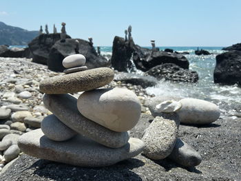 Stack of rocks at beach on sunny day