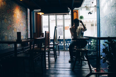 Rear view of man sitting on table