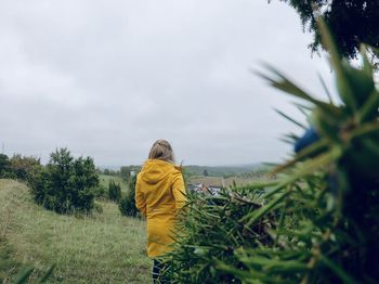 Rear view of woman on field against sky