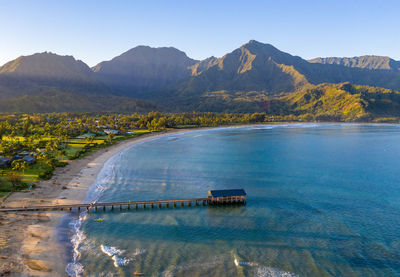 Aerial panoramic image at sunrise off the coast over hanalei bay and pier on kauai