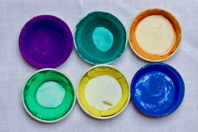 Directly above shot of powder paints in plates on table during holi