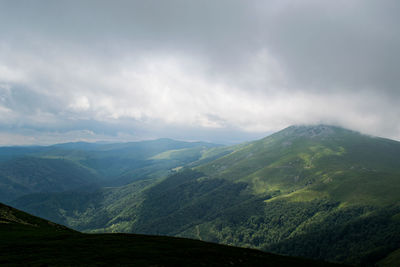 Scenic view of mountains against cloudy sky