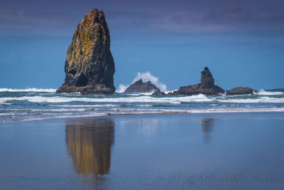 Rock formation on sea shore against sky