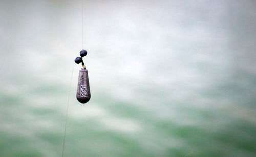 Low angle view of toy hanging on rope against sky