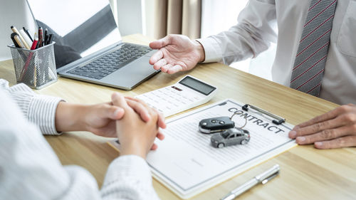 Midsection of business colleagues working on table