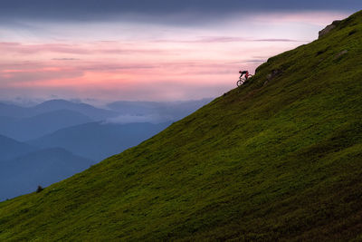 Scenic view of mountains against sky during sunset with mtb rider
