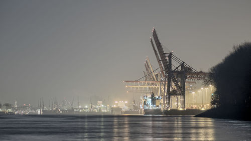 Illuminated commercial dock against sky at night