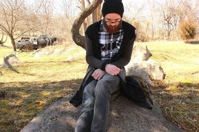 Portrait of young woman sitting on field