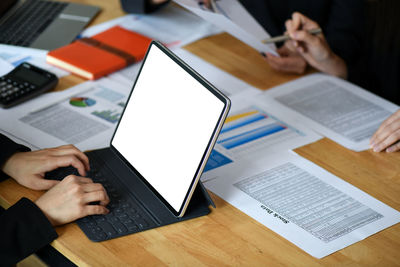 Midsection of man using laptop on table