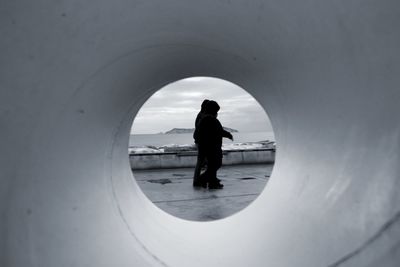 Rear view of silhouette man standing in tunnel of perspective 