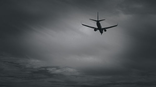 Low angle view of airplane in flight against sky