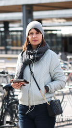 Young woman using mobile phone while standing outdoors