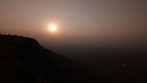 Scenic view of silhouette mountains against sky at sunset