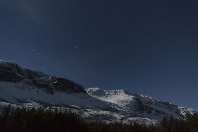 Scenic view of snowcapped mountains against sky at night