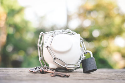 Close-up of piggy bank with key and lock on table