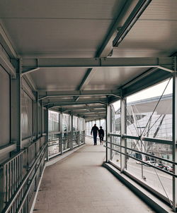 Rear view of couple walking on footbridge