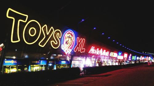 Illuminated bridge in city against sky at night