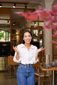 Portrait of young woman standing in cafe