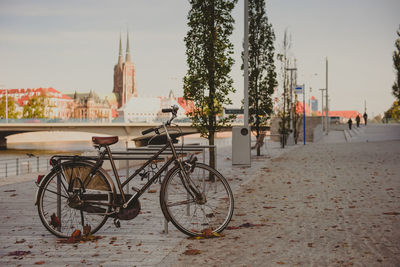 Bicycles parked on street in city against sky