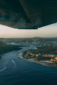 Aerial view of city by sea against sky