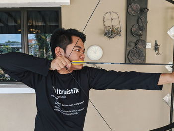 Portrait of young man playing archery