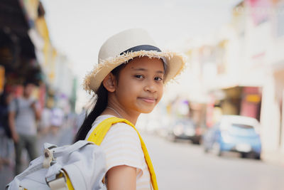 Young girl traveler with backpack standing in old town among chino portuguese style building.