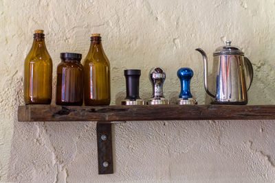 Bottles on table against wall