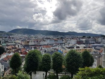 Buildings in town against cloudy sky