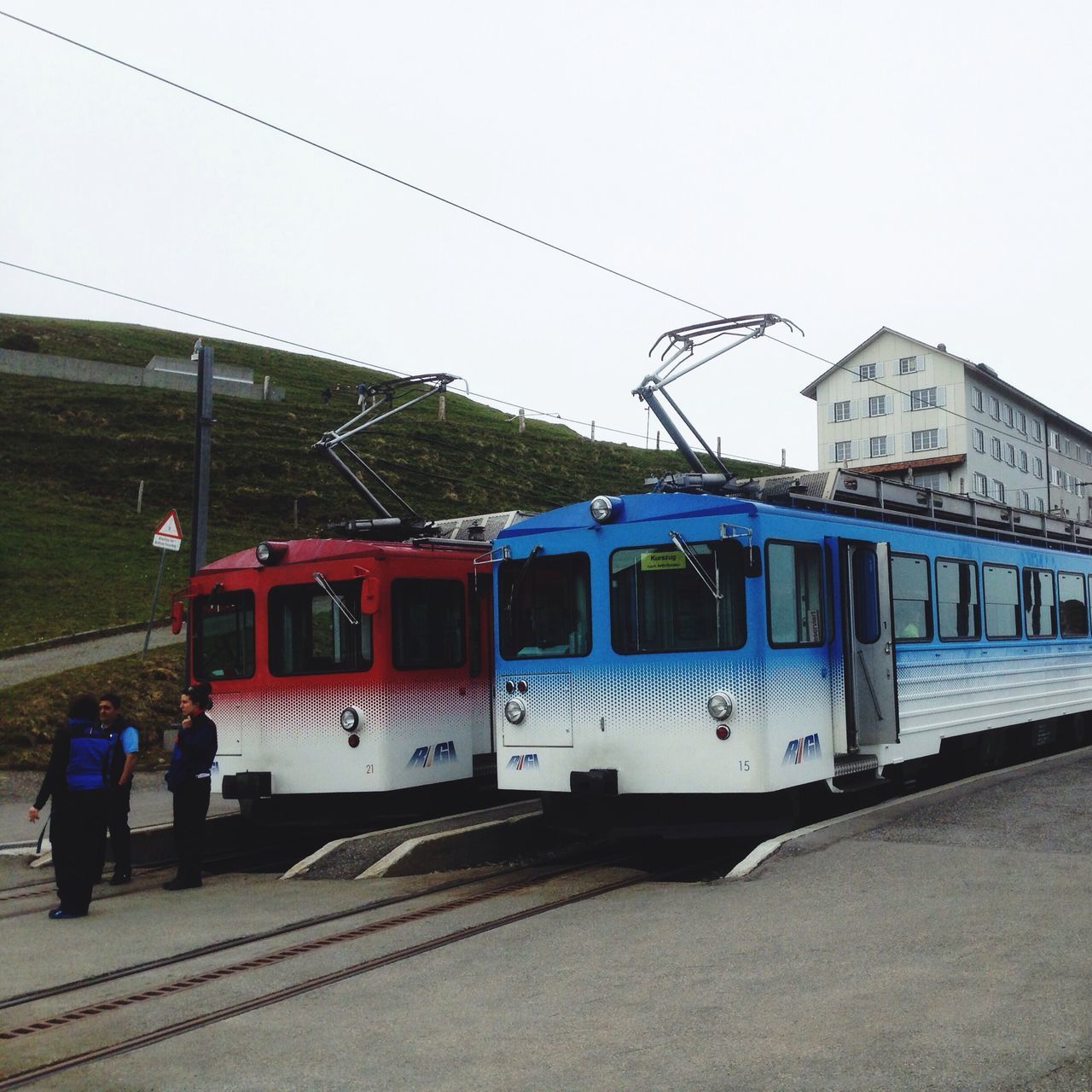 transportation, mode of transport, public transportation, train - vehicle, built structure, rail transportation, architecture, railroad track, clear sky, railroad station platform, building exterior, railroad station, travel, train, passenger train, land vehicle, day, incidental people, men