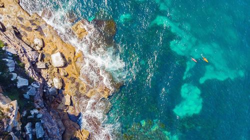 High angle view of people on rock by sea