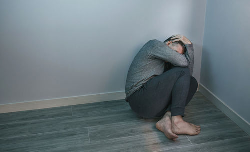 Low section of woman standing against wall