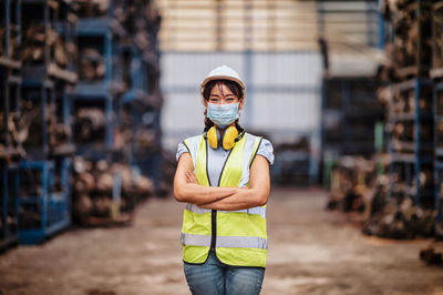 Confident pose of the engineer women wear mask while standing with his arms crossed