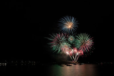 Firework display over river at night