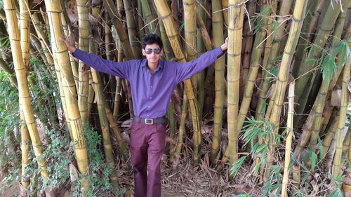 Full length of woman standing on tree trunk