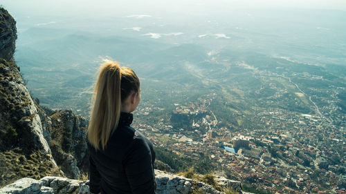 High angle view of woman looking at cityscape from mountain