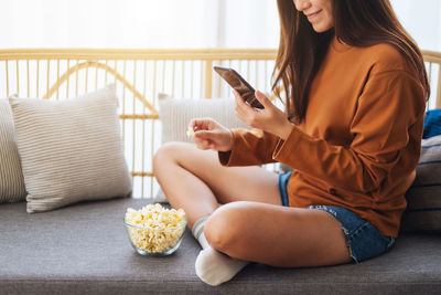 Midsection of woman using mobile phone