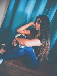 Side view of woman sitting on floor at home