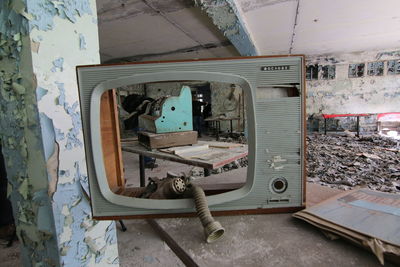 Television set on table in abandoned building